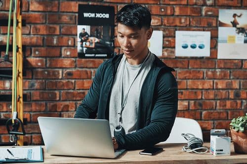 Gym staff member working on a laptop